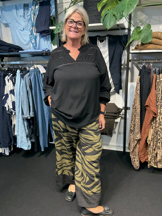 Smart plus size skjorte med flotte hul-detaljer. Den er med smock forneden på ærmet, så det nemt kan trækkes op og sættes hvor man ønsker på armen. Den findes op til en str. 58.