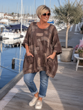 AI-genereret billede af Sille plussize bomuldstunika i let vævet bomuld med grafisk print, rund hals og lommer. Tunikaen vises på en plus-size model og fås i flere farver.