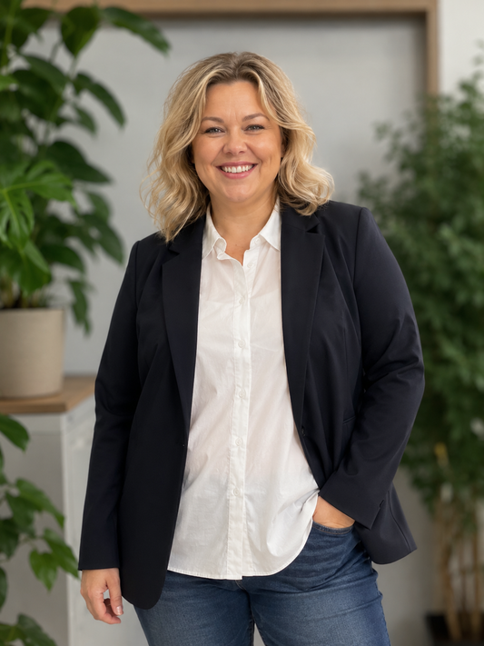 Sina 1 Plus Size blazer i navy med klassisk snit, reverskrave og komfortabel pasform. Vist på kurvet model i størrelse 46/48 stylet med hvid skjorte og jeans.billed er i generet.