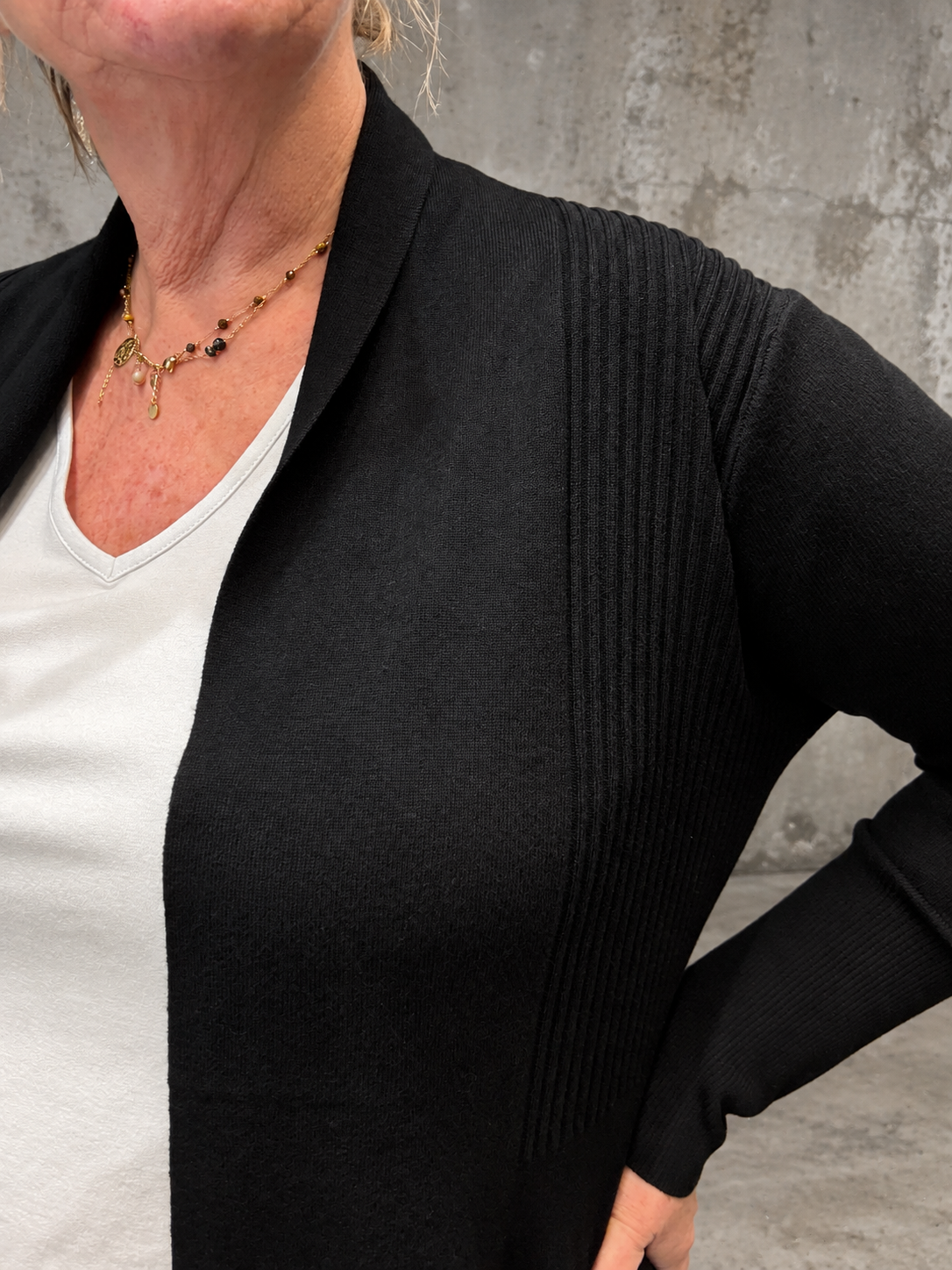 **Alt-tekst:** Samanda 2 plus size cardigan fra Wasabi i sort med lange ærmer, åben front og ribstrikkede detaljer ved skuldrene. Findes også i marine. Billedet er AI-genereret.
