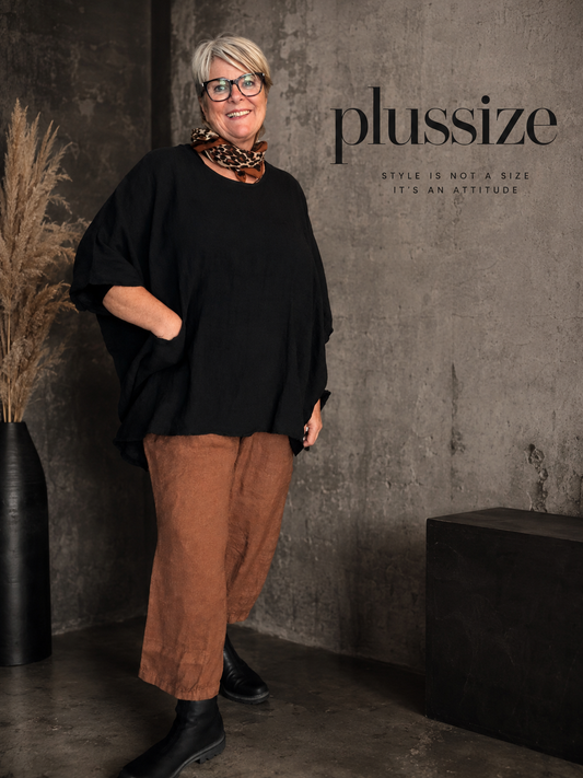 Susanne plussize bomuldstunika (AI-genereret billede)

AI-genereret billede af en smilende plus-size model iført Susanne bomuldstunika i mørk brun. Tunikaen har en løs, oversize pasform med rund hals, korte brede ærmer og store påsyede lommer foran. Den er stylet med rustfarvede bukser og komfortable sko i et råt industrielt miljø, som fremhæver tunikaens afslappede og moderne udtryk. Ideel til kvinder, der ønsker komfort, bevægelsesfrihed og et stilfuldt hverdagslook.
