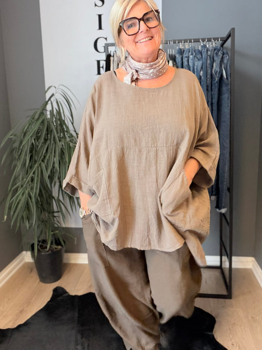 Susanne er en tunika til plus size kvinder, som elsker et oversize look. Den findes i mange forskellige farver. Den er onesize og passes af alt fra en str. 42 til og med str. 54. Her ses den i farven Taupe. 