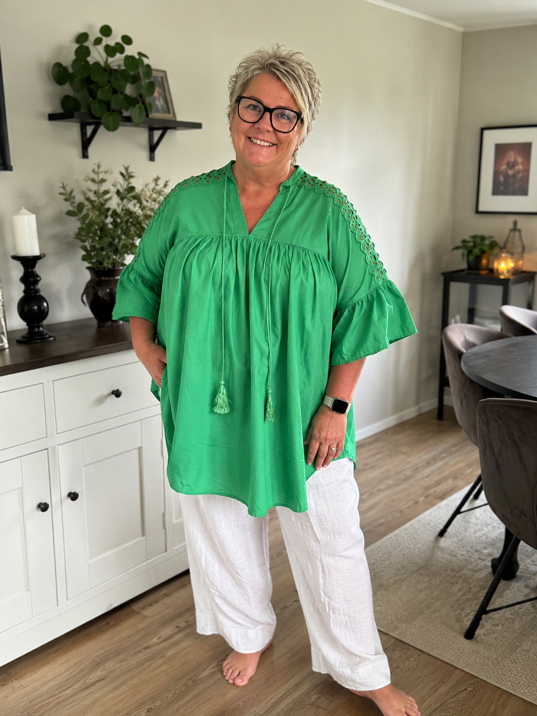 Den smukke plus size tunika ved navn Thea, her i grøn. Jeg har sat den til Mimi jeansen, det er den med stræk, lommer bindebånd og god pasform. 

Billedet er genereret vha. AI-teknologi for at vise tunikaen på en person. 