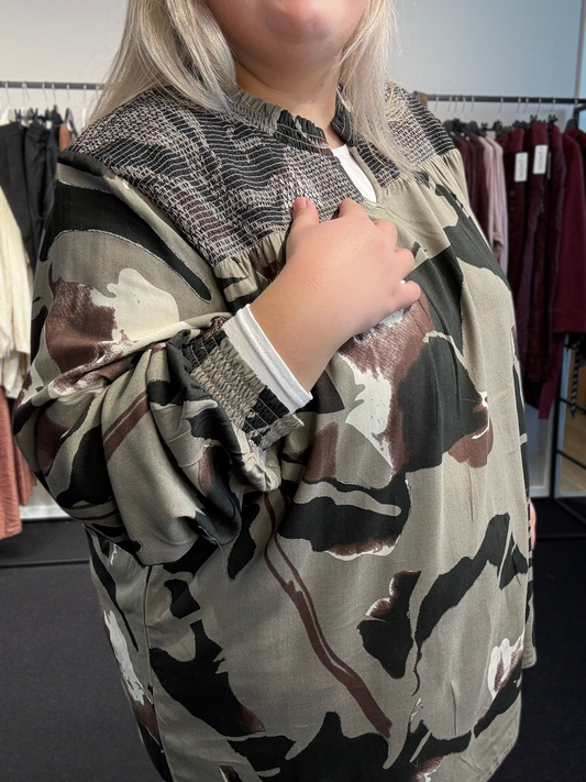 Smuk plus size bluse i anderledes mønster. Den er i nogle flotte jordfarver, som er nemme at sætte sammen med andre farver. 
