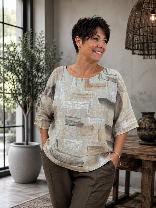 Bodil bluse i blød og let bomuld med et moderne, grafisk print. Blusen har en afslappet, rummelig pasform, rund hals og 3/4-ærmer, som giver et komfortabelt og stilfuldt look. Den er nem at kombinere med både hørbukser, jeans og shorts og fås i flere flotte farver. Perfekt til kvinder, der ønsker en luftig bomuldsbluse med god bevægelsesfrihed og et moderne udtryk.billed er ai generet
