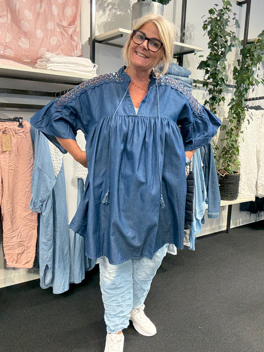 Smuk tunika med blonde på skulderen. Den har v-hals og så er den skåret over brystet, hvorefter den får ud i a-facon. Virkelig smuk tunika, som vil klæde de fleste plus size kvinder.