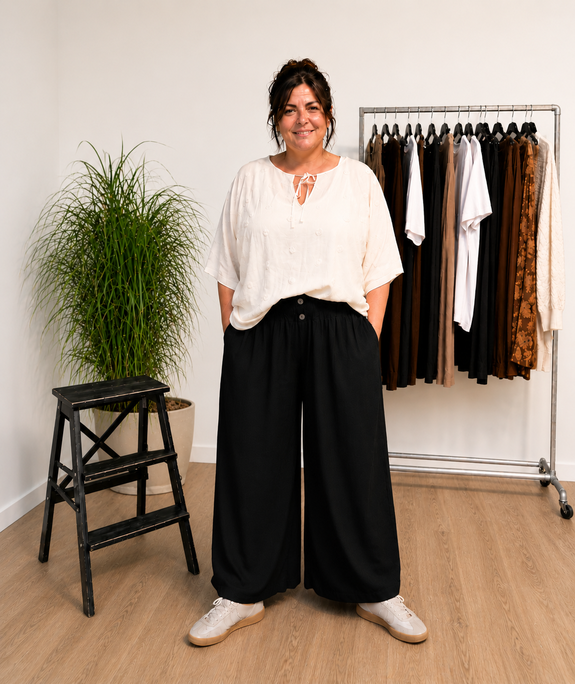 "Model i Tora viddebuks med bred smock-elastik i taljen, dekorative knapper og vide ben. Buksen vises i Grå sammen med en løs beige bluse. Modellen er str. 46/48 og 168 cm høj." Billed er ændret i Ai
