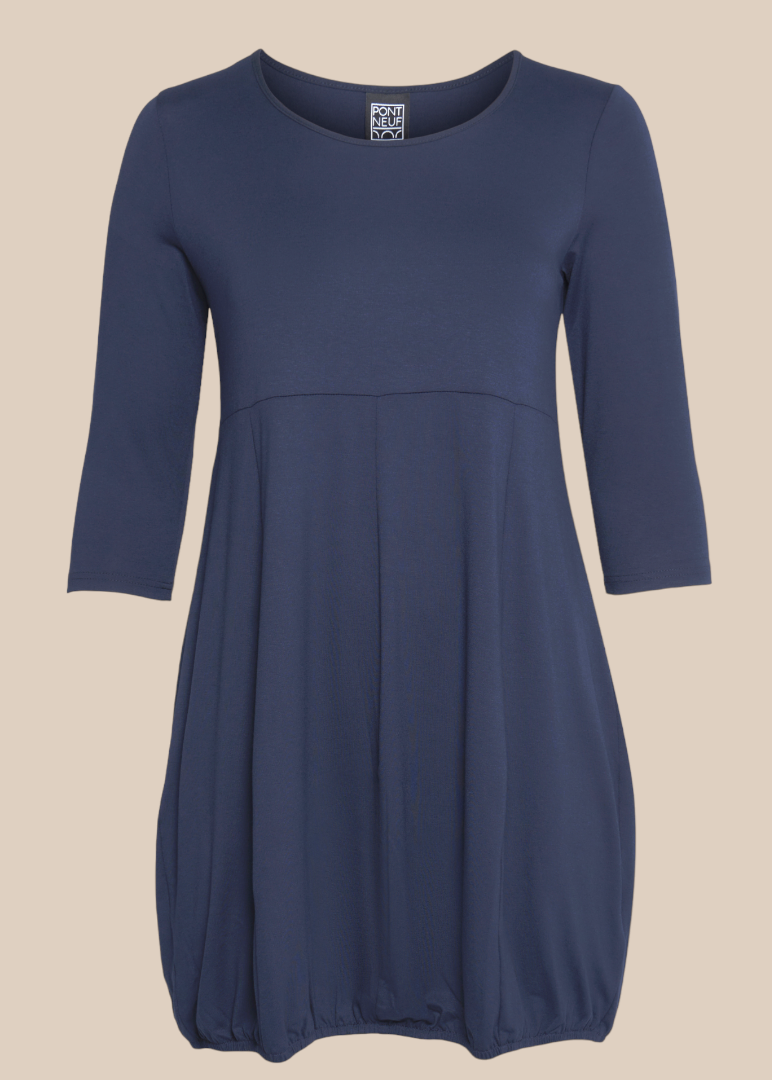 Hilda er plus size kjolen, som du vil elske. Modellen har en fin ballon-effekt, som er perfekt til de fleste plus size kvinder. Kvaliteten er en lækker viskose. Derudover har den 3/4 ærmer og rund hals. Her ses den i marine.