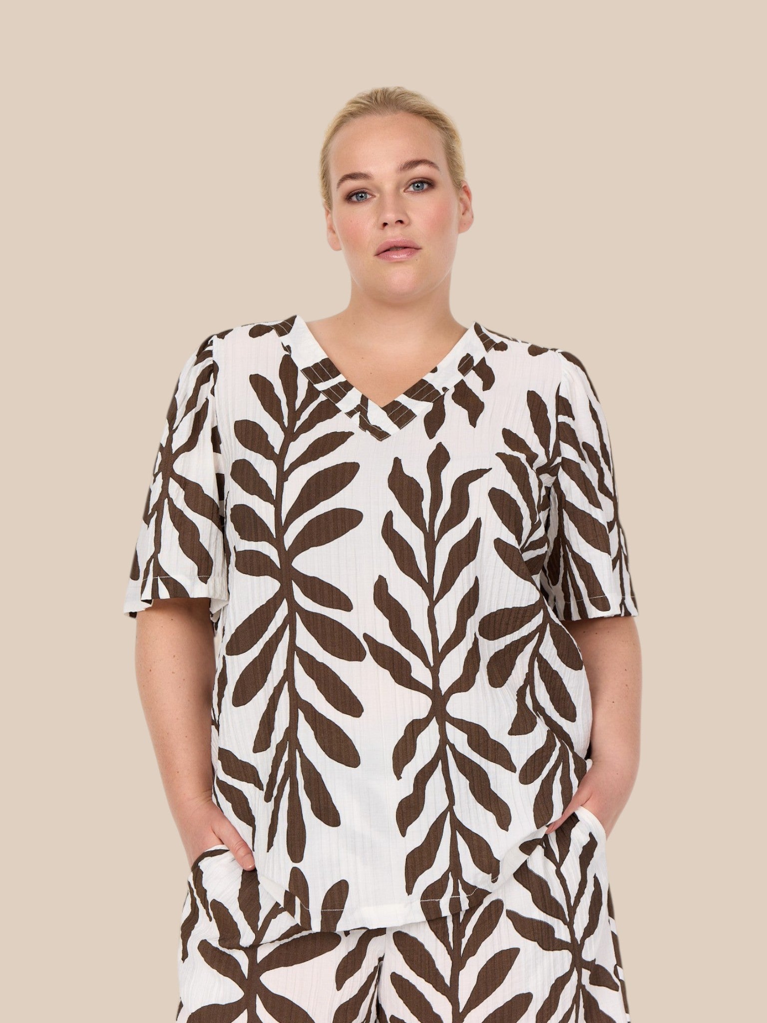 Smuk plus size bluse fra Wasabi, som er perfekt til dig som elsker en løs pasform. Den er med v-hals korte ærmer og så er den perfekt til foråret og sommeren.