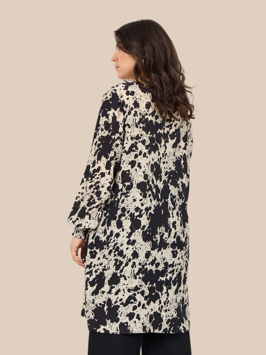 Smart plus size tunika i unikt print. Den er med lange ærmer, v-hals og så er der smock-detalje ved ærmets afslutning. Fra str. 42 til og med str. 58.