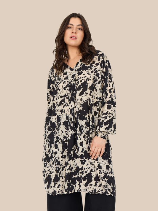 Smart plus size tunika i unikt print. Den er med lange ærmer, v-hals og så er der smock-detalje ved ærmets afslutning. Fra str. 42 til og med str. 58.