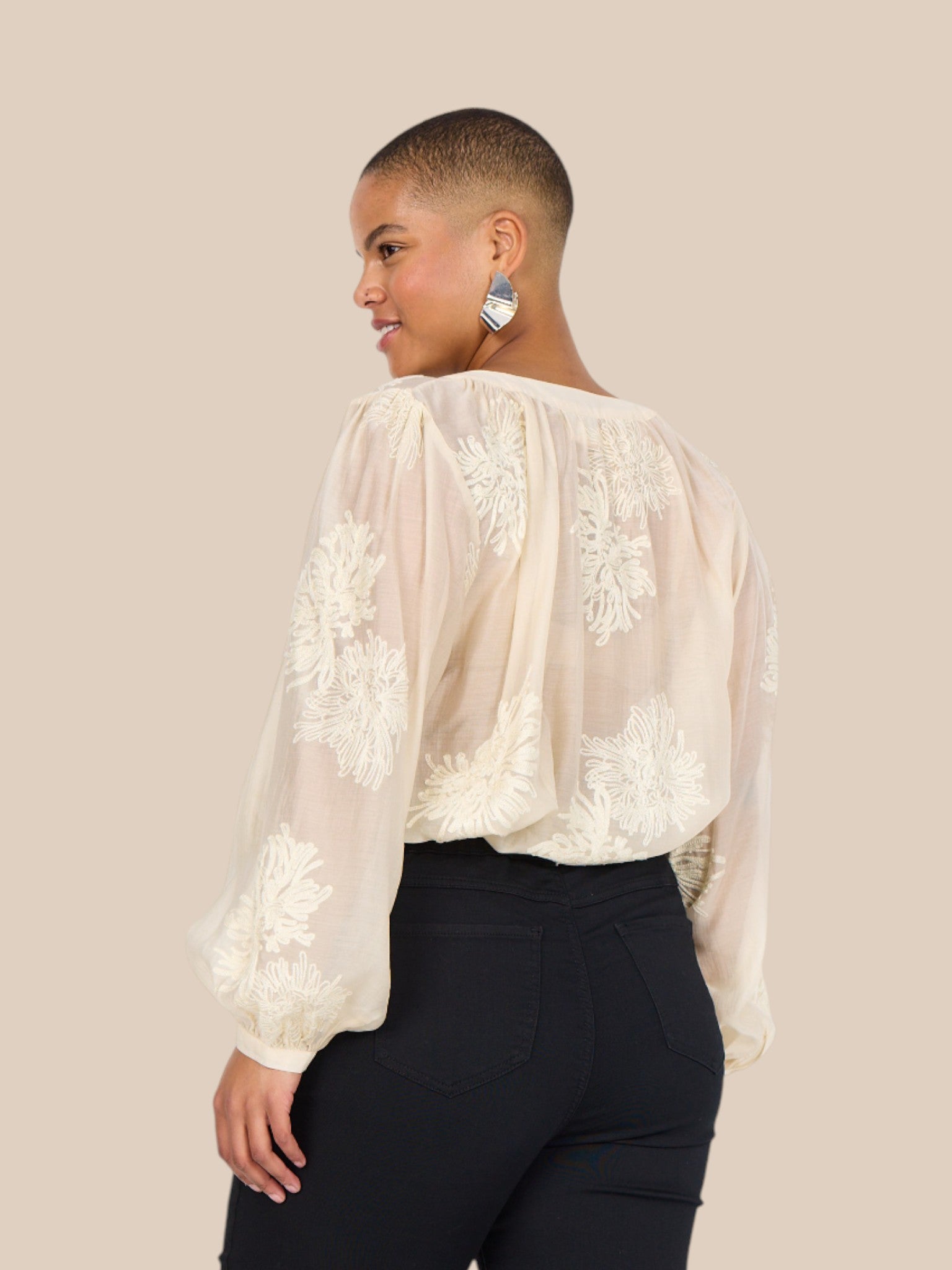 Feminin plus size bluse i en smuk fløde-farve. Den er med broderede blomster, som gør den lidt pyntet.