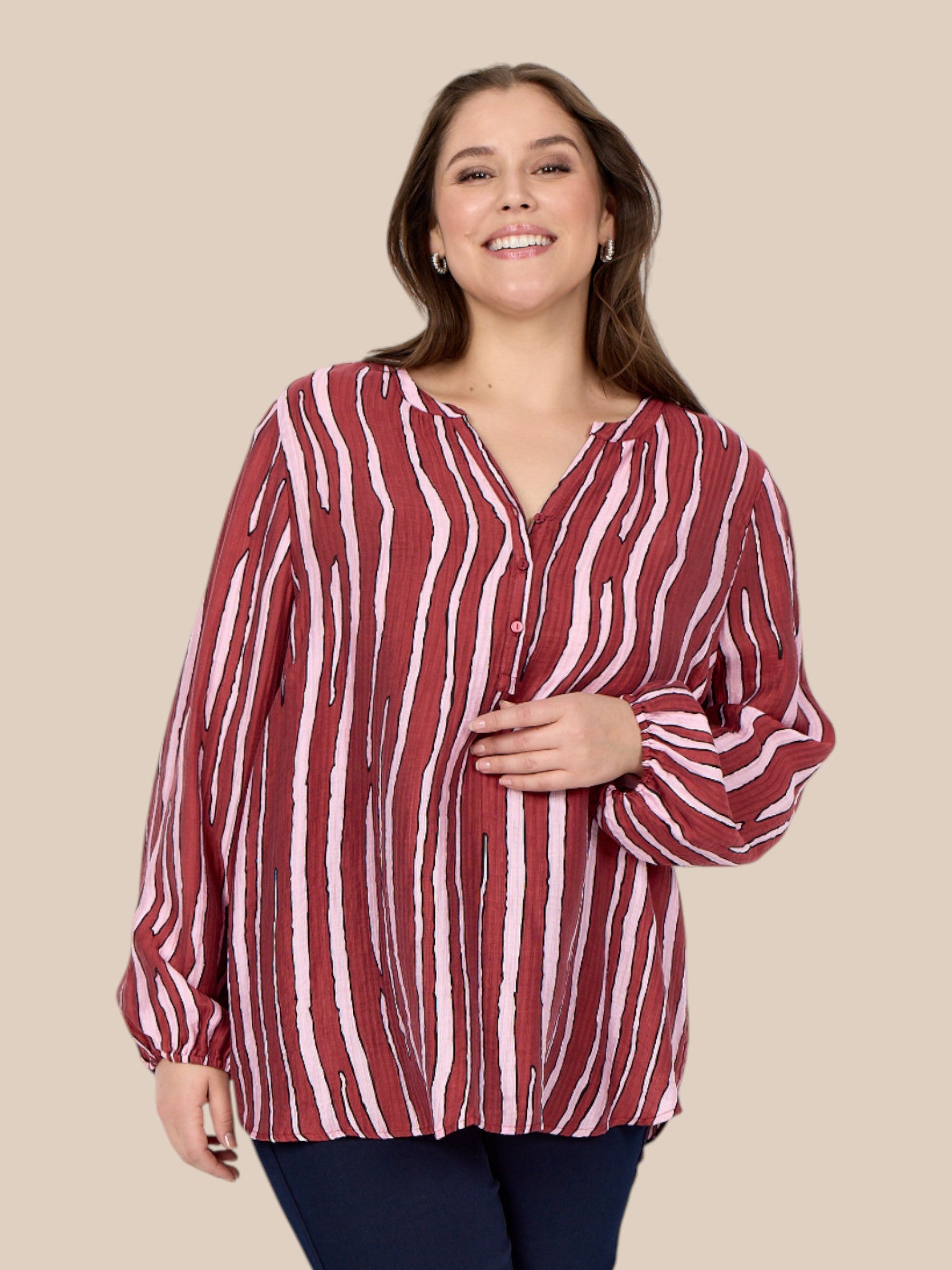 Stribet bluse i de flotteste farver. Den er med stolpelukning og lille v-hals. Her får du en bluse der passer perfekt til de fleste plus size kvinder. 