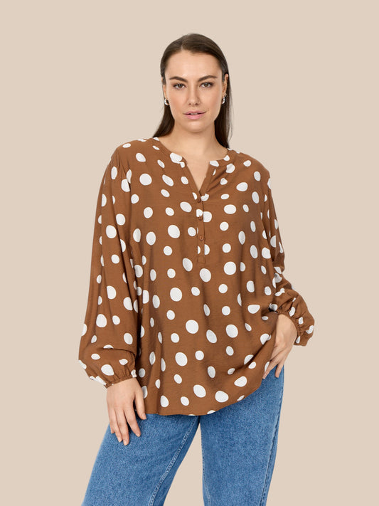 Smuk bluse med prikker og stolpelukning. Perfekt til plus size kroppen.