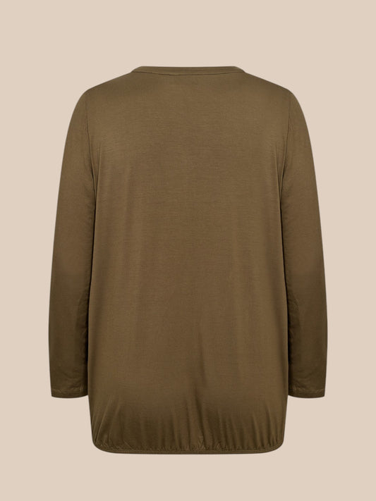 Flot plus size bluse med v-hals og stolpelukning hvor der er påsat flæsekant, som giver et feminint udtryk.
