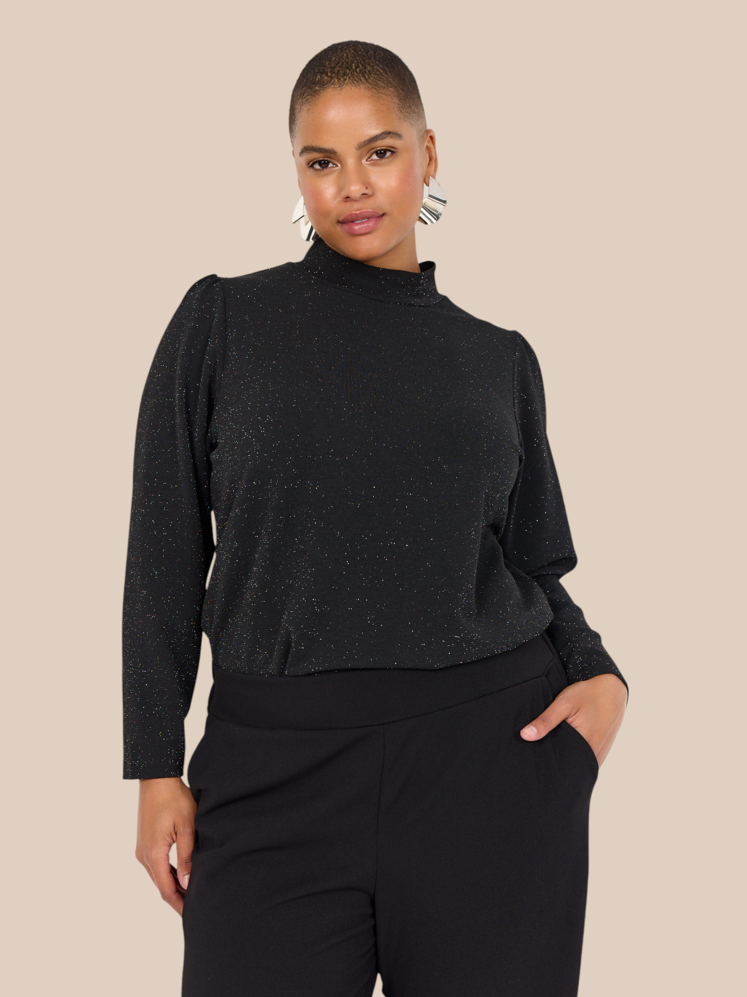 Smuk plus size bluse med glimmer. Den passer til bukserne af samme navn. Den er med lange ærmer og turtleneck. 