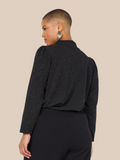 Smuk plus size bluse med glimmer. Den passer til bukserne af samme navn. Den er med lange ærmer og turtleneck. 