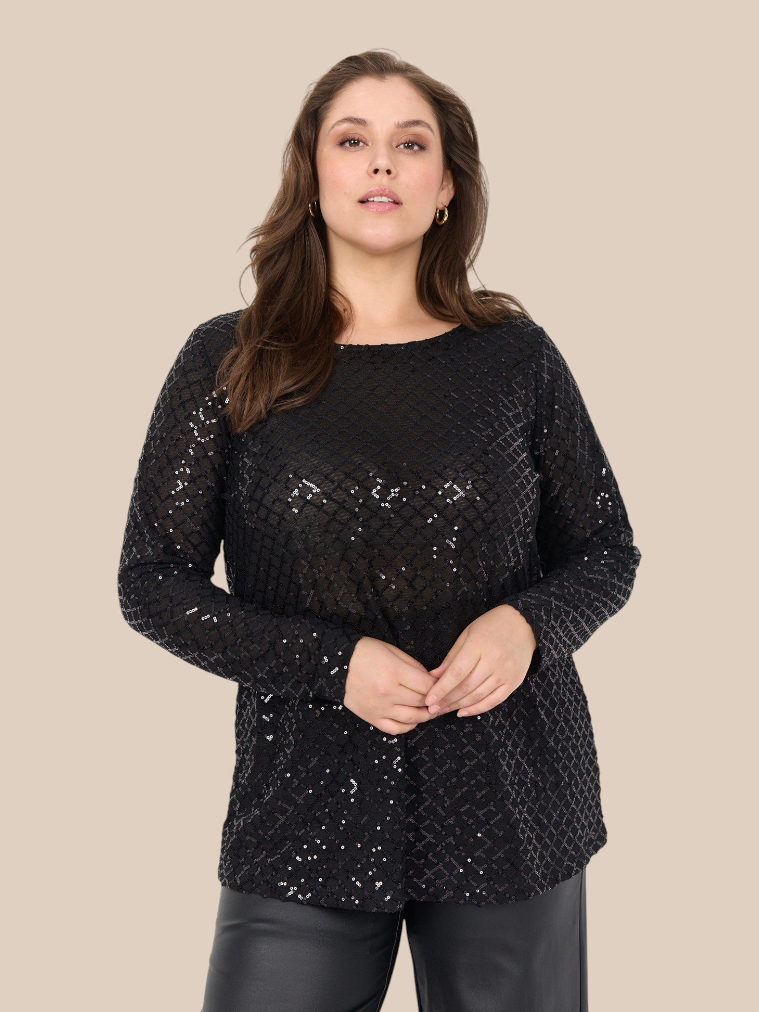 Plus size bluse i et flot paillet mønster. Den er med lange ærmer, rund hals og har en lille lykke i ryggen. Perfekt til årstidens fester. 