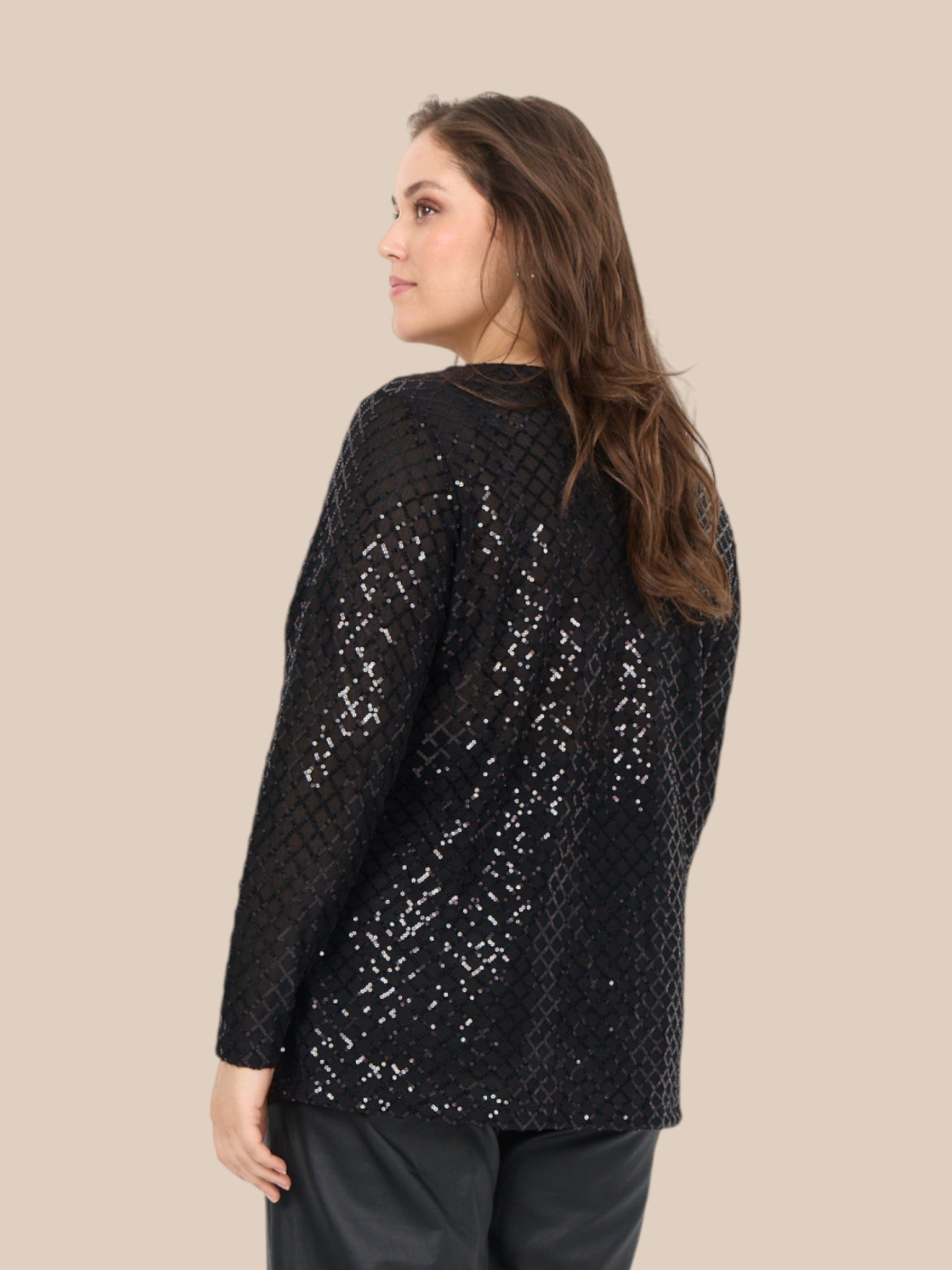 Plus size bluse i et flot paillet mønster. Den er med lange ærmer, rund hals og har en lille lykke i ryggen. Perfekt til årstidens fester. 