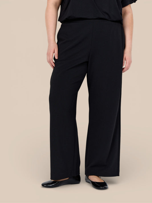 Behagelig buks til plus size kvinden. Den er med glat finish, lommer og brede ben.