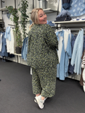 Plus size sæt i et smart leopard-print, som findes i denne grønne udgave og en flot brun. Sættet her består af Melina 4 buksen og Melina 2 skjorten. Modellen har en str. 54/56 på i begge styles, men det går faktisk op til en str. 58. 