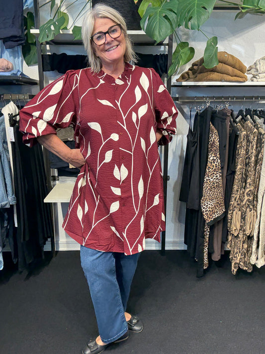 Smuk mønstret plus size tunika fra mærket Wasabi Concept. Den er gennemknappet og kan bruges både åben og lukket.