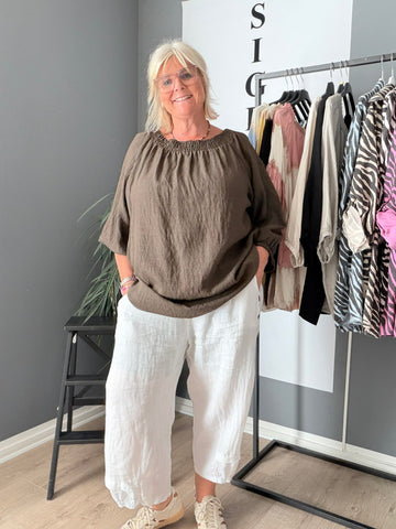 Molly plussize bluse med elastik omkring halsen, der giver en behagelig og fleksibel pasform til kurvede kvinder, perfekt til både hverdag og fest.