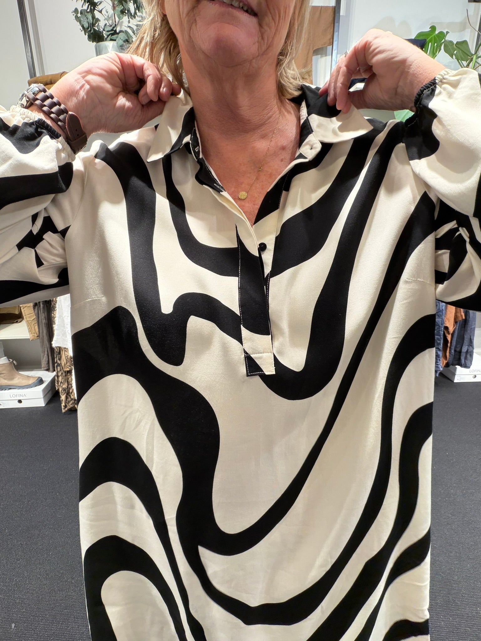 Anderledes tunika til plus size kvinden. Den er med stolpelukning, lange ærmer og en klassisk skjortekrave. 