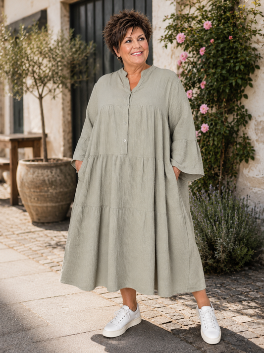 Ella er en lækker kjole i facon, som er en en behagelig ble-kvalitet i bomuld. Den er med stolpelukning og har en rigtig god pasform. Til plus size kvinder i str. 42 til 54.

Billedet er genereret vha. AI for at vise kjolen på en person