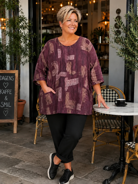 AI-genereret billede af Sille plussize bomuldstunika i let vævet bomuld med grafisk print, rund hals og lommer. Tunikaen vises på en plus-size model og fås i flere farver.